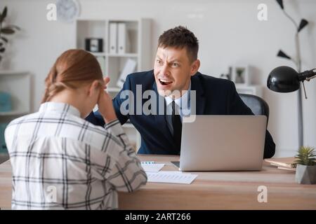 Angry boss scolding his secretary in office Stock Photo
