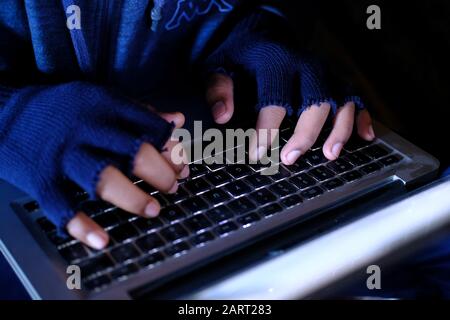 Close up of Hooded hacker steeling data from laptop  Stock Photo