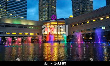 Multi-colored dancing fountains near the twin towers of Petronas in Kuala Lumpur. Stock Photo