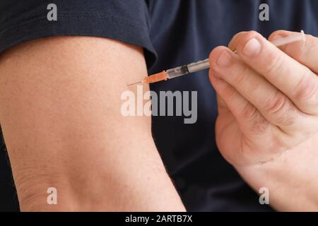 Diabetic man giving himself insulin injection, closeup Stock Photo