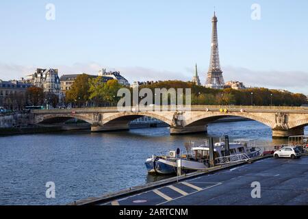 Eiffel tower and bridge with Seine river view and empty docks in a sunny autumn day in Paris, France Stock Photo