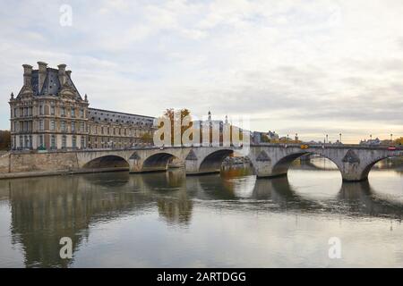 Louvre Palace and bridge with Seine river view in an autumn day in Paris, France Stock Photo