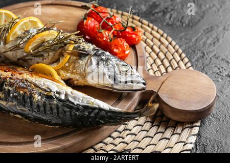 Board with baked mackerel fish on table Stock Photo