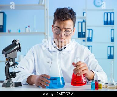 The funny mad chemist working in a laboratory Stock Photo