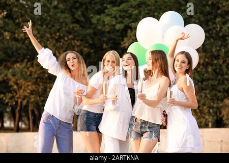 Beautiful young women with champagne at hen party outdoors Stock Photo