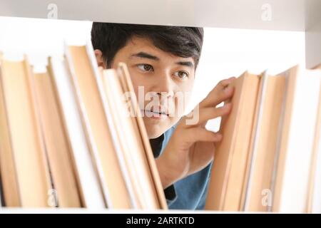 Asian student choosing book in library Stock Photo