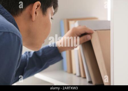 Asian student choosing book in library Stock Photo