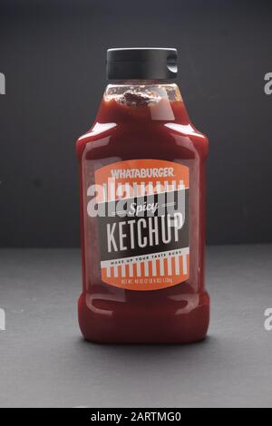Plastic squeeze bottle of spicy tasting tomato ketchup made by Whataburger fast food chain on dark background Stock Photo