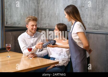 Man paying bill in restaurant through terminal Stock Photo