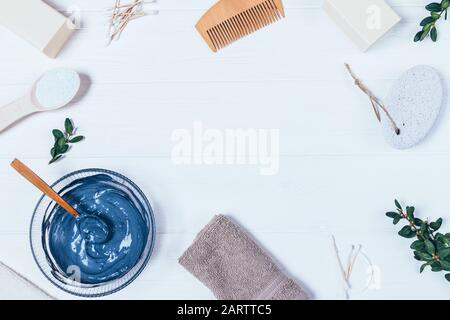 Beauty products for home skin care clay mask, pumice, soap and towel on white wooden table, top view. Stock Photo