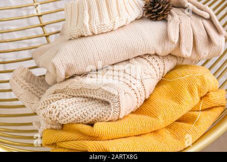 Winter clothes in armchair, closeup Stock Photo