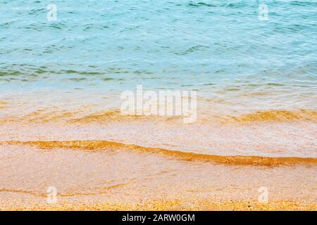 The texture of sea water with a fragment of a small shell rock near the shore Stock Photo