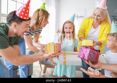 Big family greeting little girl with Birthday presents at home Stock Photo