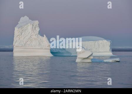 Large floating icebergs at sunset, Scoresby Sund. Kangertitittivaq, Greenland, Denmark