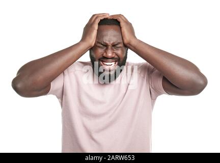 Handsome African-American man suffering from head ache on white background Stock Photo