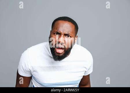Confused African-American man on grey background Stock Photo