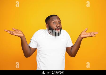 Helpless African-American man on color background Stock Photo