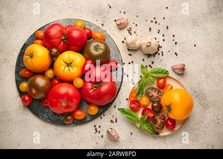 Different fresh tomatoes and spices on light background Stock Photo