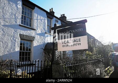 House for sale sign outside a traditional stone cottage property in St Briavels village Gloucestershire England UK  Great Britain  KATHY DEWITT Stock Photo