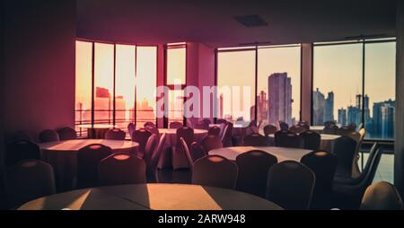 blurry image of empty dining room with city skyline and sunset sky background  - Stock Photo