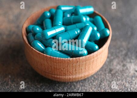 Bowl with spirulina pills on table Stock Photo