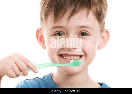 Portrait of little boy brushing teeth on white background Stock Photo