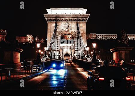 View to Chain bridge and city traffic. Beautiful evening or night scene of illuminating ancient architecture.