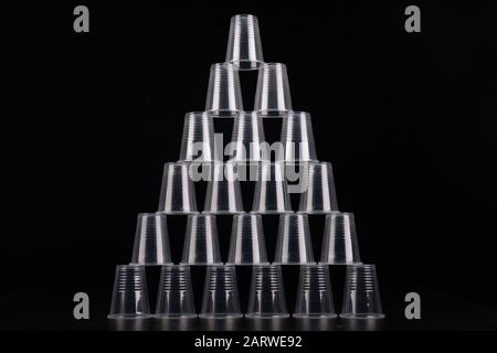 Plastic versus cardboard cups. Disposable tableware set on a table. Dark background. Stock Photo