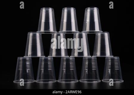 Plastic versus cardboard cups. Disposable tableware set on a table. Dark background. Stock Photo