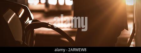 Businessman using mobile phone while charging electric car Stock Photo