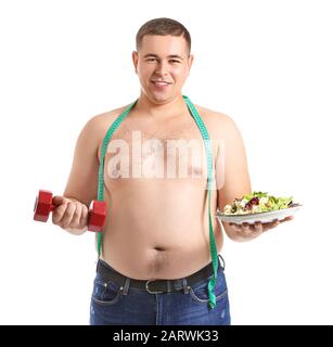 Overweight man with dumbbell, salad and measuring tape on white background. Weight loss concept Stock Photo