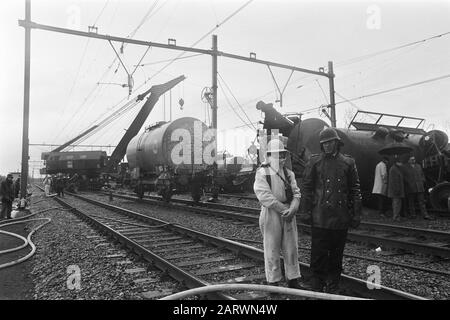 Train wagons with rapidly flammable liquids derailed in Utrecht  Tankwagon is put on track with crane Date: 30 april 1970 Location: Utrecht (city), Utrecht (province) Keywords: mountains, cranes, derailment, railway accidents, railway workers, wagons Stock Photo