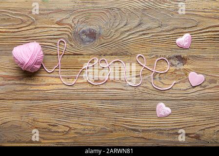 Word LOVE made of knitted yarn on wooden background Stock Photo