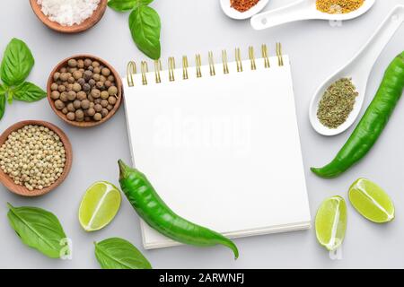 Empty notebook with different spices on white background Stock Photo