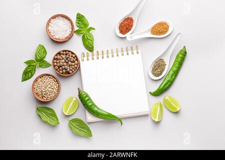 Empty notebook with different spices on white background Stock Photo