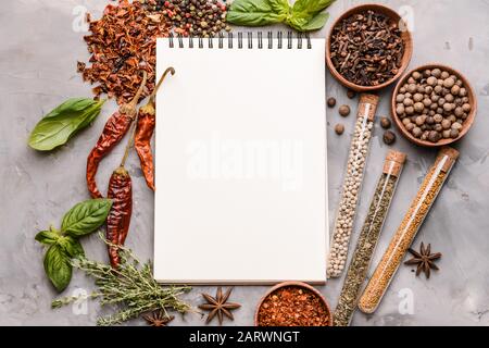 Empty notebook with different spices on grunge background Stock Photo