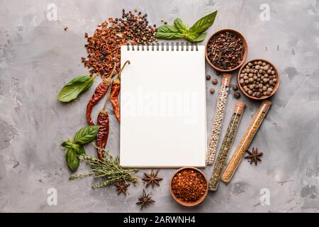 Empty notebook with different spices on grunge background Stock Photo