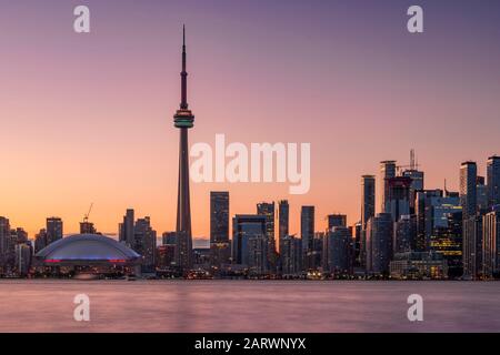Toronto Skyline at sunset featuring the CN Tower across Lake Ontario, Toronto, Ontario, Canada Stock Photo