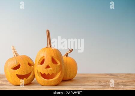 Halloween pumpkins on wooden table against grey background Stock Photo