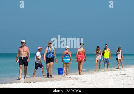 HOLMES BEACH, ANNA MARIA ISLAND, FL - May 1, 2018: People on vacation taking a walk on the beach  and enjoying a beautiful sunny day on the Gulf Coast Stock Photo