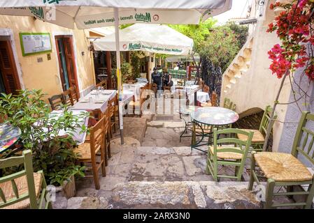 Athens - May 6, 2018: Street cafe with flowers and plants in Plaka district, Athens, Greece. Plaka is one of the main tourist attractions of Athens. Stock Photo