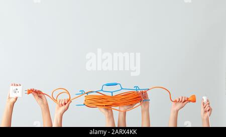 Female hands with electrician's tools on light background Stock Photo
