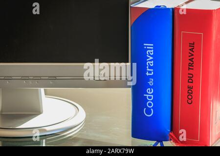 Paris, France - March 17, 2016 : A French labor code book is pictured with computer on a spring day Stock Photo