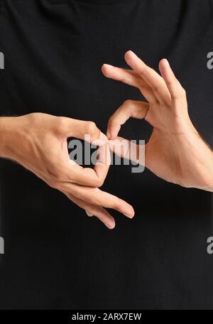 Young deaf mute man using sign language, closeup Stock Photo
