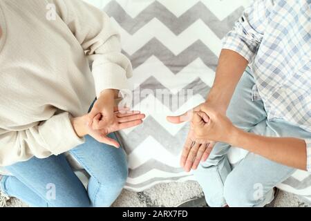 Young deaf mute couple using sign language at home Stock Photo