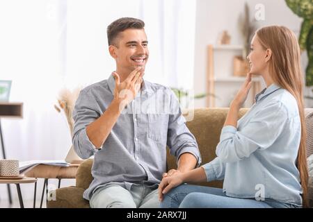 Young deaf mute couple using sign language at home Stock Photo