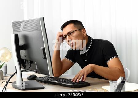 Asian programmer working on computer in office Stock Photo