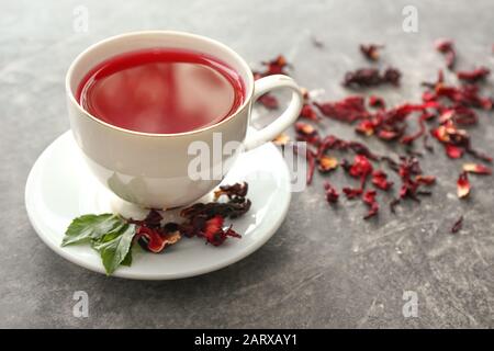 Cup of hibiscus tea on grey background Stock Photo