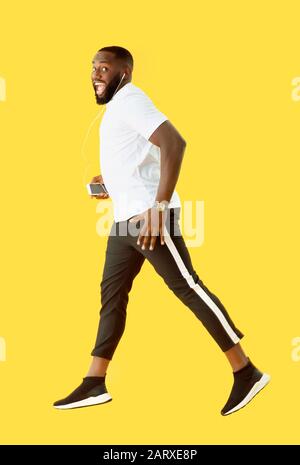 African-American man listening to music on color background Stock Photo