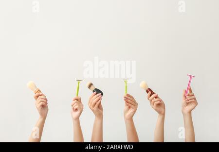 Hands with different tools for shaving on white background Stock Photo